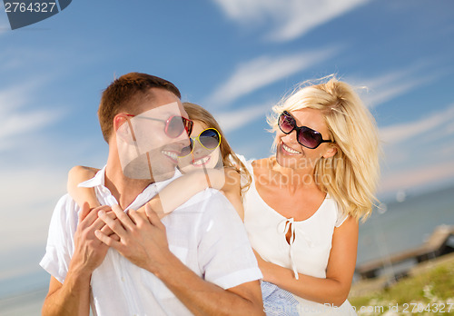 Image of happy family in sunglasses having fun outdoors
