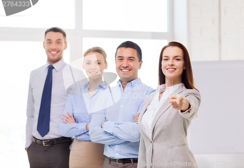 Image of businesswoman in office pointing finger at you