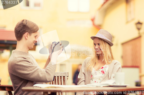 Image of couple taking photo picture in cafe