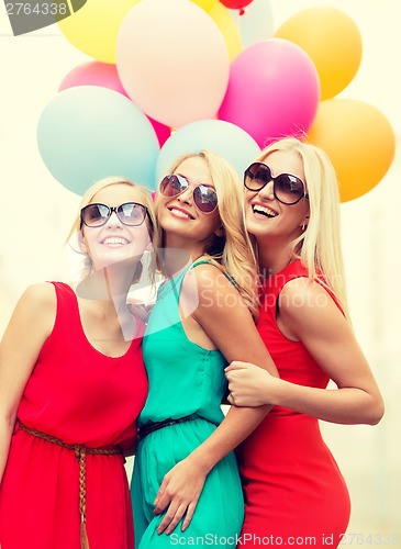 Image of beautiful girls with colorful balloons in the city