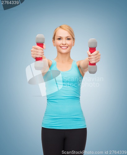 Image of young sporty woman with light dumbbells