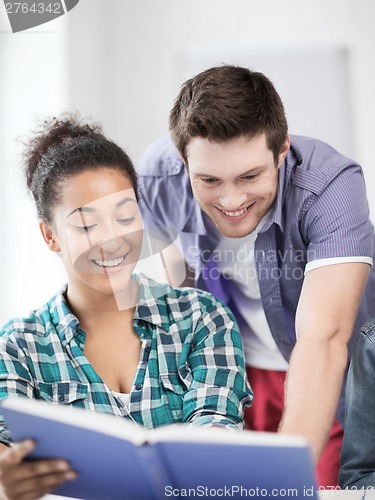 Image of students reading book at school