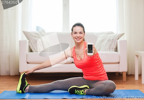 Image of smiling teenage girl streching on floor at home