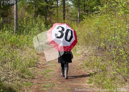 Image of Woman in the forrest with a traffic sign umbrella