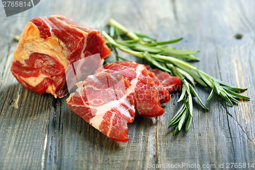 Image of Tasty meat and a sprig of rosemary. 