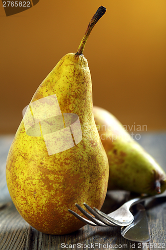 Image of Ripe pears, fork and knife.