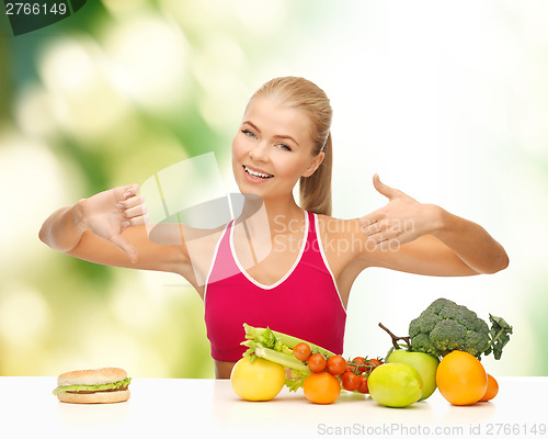 Image of woman with fruits and hamburger comparing food