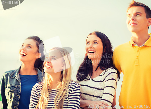 Image of group of friends looking up on the beach