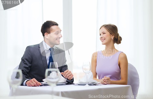 Image of smiling couple looking at each other at restaurant