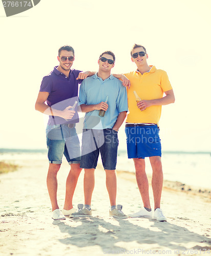 Image of friends on the beach with bottles of drink