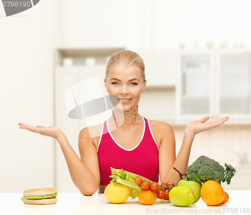 Image of smiling woman with fruits and hamburger