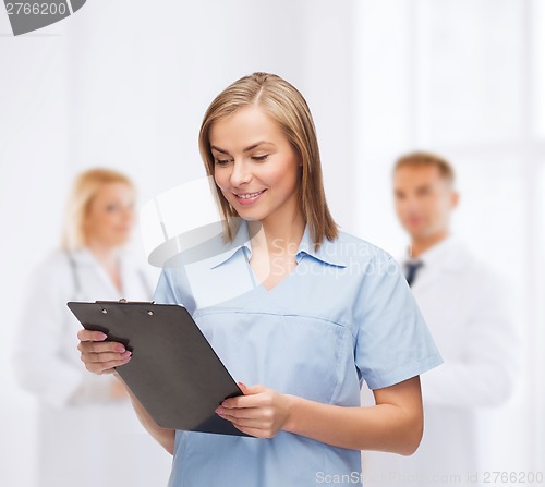 Image of smiling female doctor or nurse with clipboard