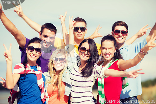 Image of group of friends having fun on the beach