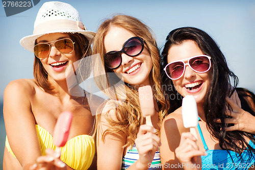 Image of girls in bikinis with ice cream on the beach