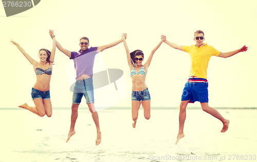 Image of group of friends or couples jumping on the beach