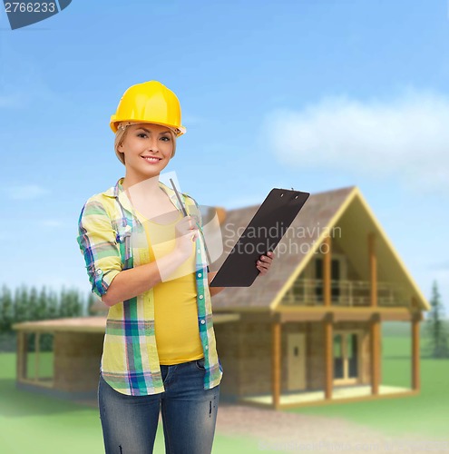 Image of smiling woman in helmet with clipboard