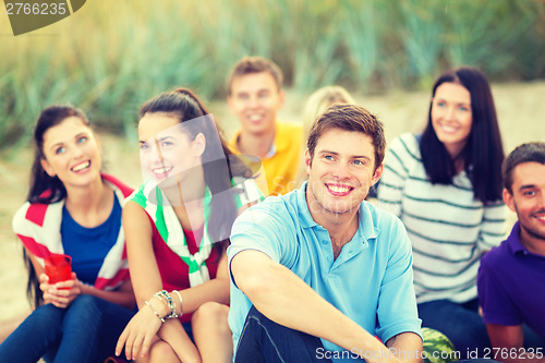 Image of group of friends looking up on the beach