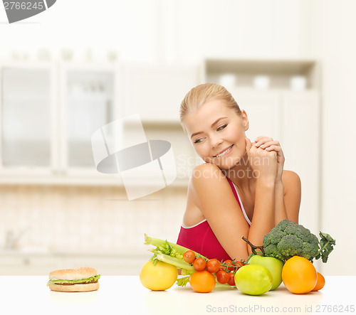 Image of doubting woman with fruits and hamburger