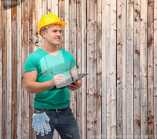 Image of smiling man in helmet with clipboard