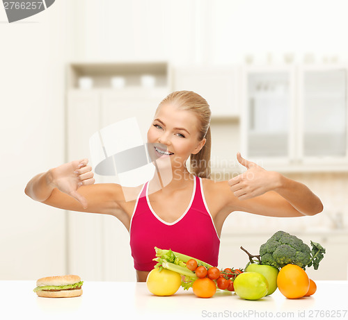 Image of woman with fruits and hamburger comparing food