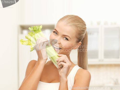 Image of woman biting piece of celery or green salad