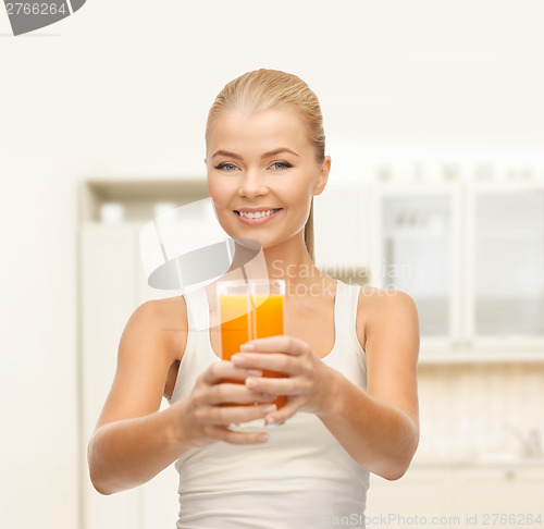 Image of smiling woman holding glass of orange juice