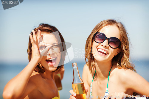 Image of girls with drinks on the beach chairs