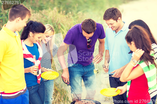 Image of group of friends having picnic on the beach