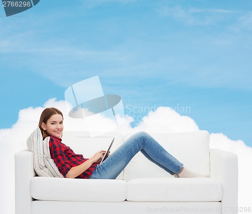 Image of teenage girl sitting on sofa with tablet pc