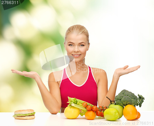 Image of smiling woman with fruits and hamburger