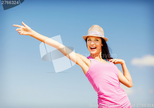 Image of girl in hat showing direction on the beach