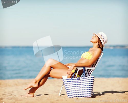 Image of girl sunbathing on the beach chair