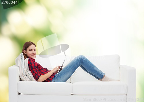 Image of teenage girl sitting on sofa with tablet pc