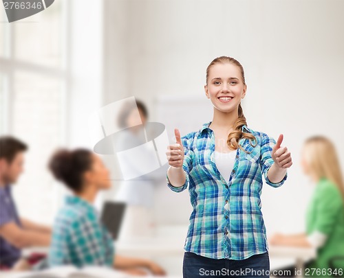 Image of young woman in casual clothes showing thumbs up