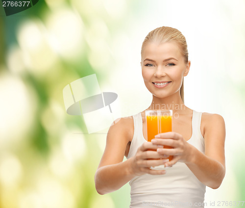 Image of smiling woman holding glass of orange juice