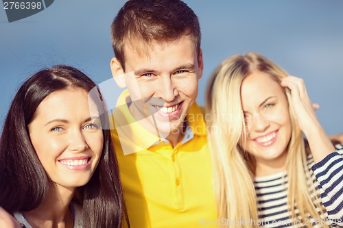 Image of group of friends having fun on the beach