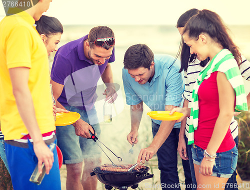 Image of group of friends having picnic on the beach