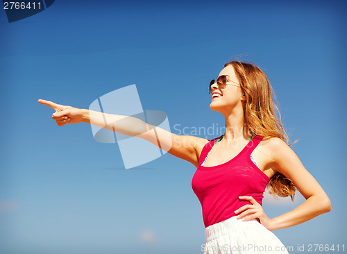 Image of girl showing direction on the beach