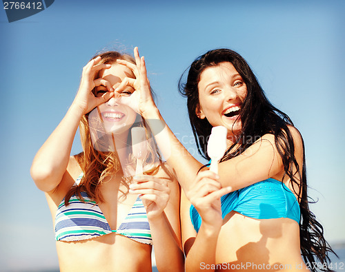 Image of girls in bikinis with ice cream on the beach