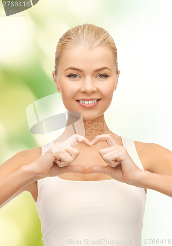 Image of smiling woman showing heart shape gesture