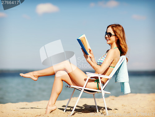 Image of girl reading book on the beach chair