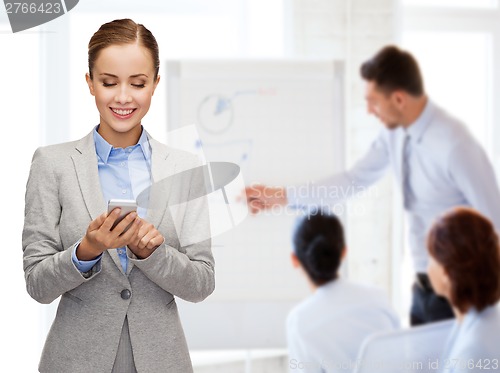 Image of young smiling businesswoman with smartphone