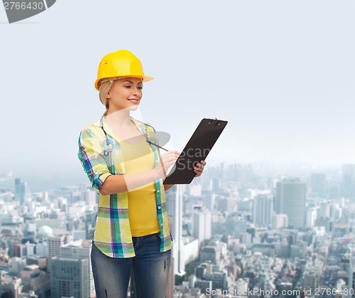 Image of smiling woman in helmet with clipboard