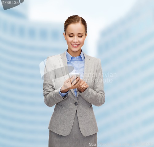 Image of young smiling businesswoman with smartphone