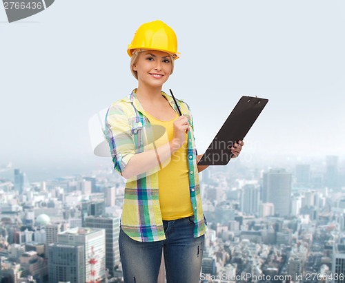 Image of smiling woman in helmet with clipboard