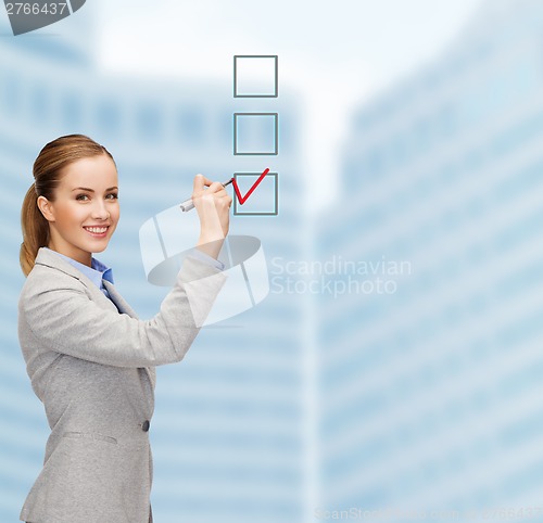 Image of businesswoman writing something in air with marker