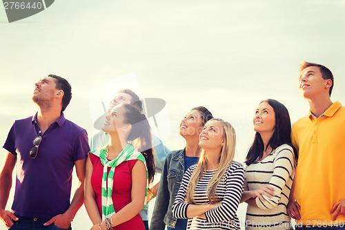 Image of group of friends looking up on the beach