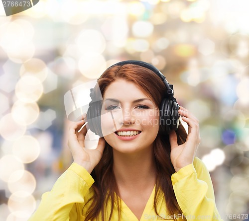 Image of smiling young girl in headphones at home