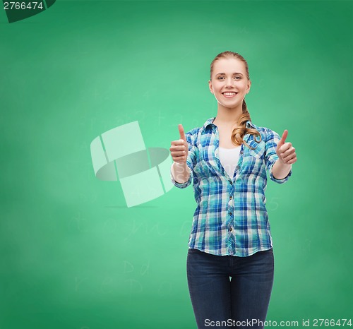 Image of young woman in casual clothes showing thumbs up