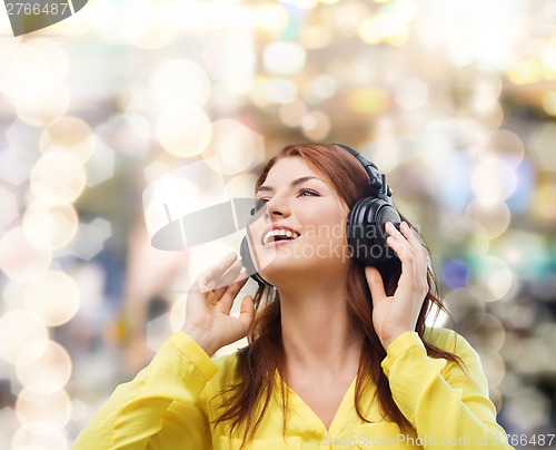 Image of smiling young girl in headphones at home